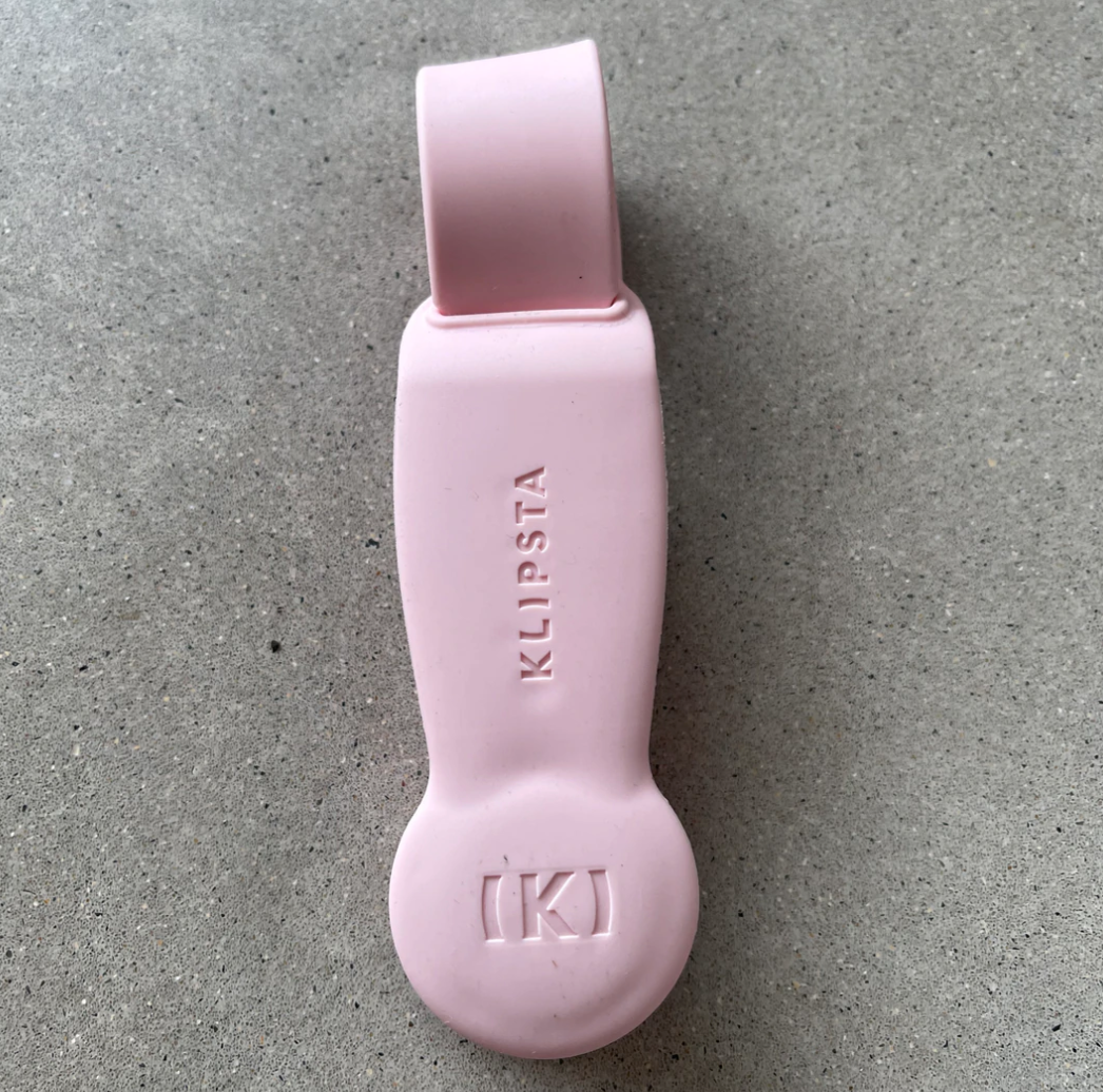 Light pink silicone Klipsta hat clip on a grey surface