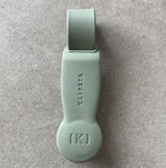 Sage green Klipsta hat clip on a grey stone surface