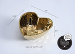 Pampa Bay porcelain heart-shaped bowl featuring a lustrous metallic gold hammered finish, a decorative beaded rim, and measuring 5.5 by 5.75 by 2.5 inches