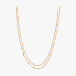 Two thin layered gold rope twist chains draped against a plain white background