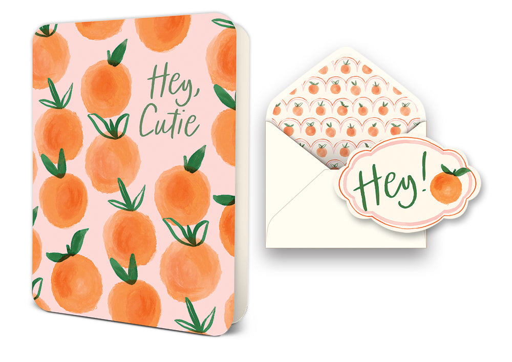 Greeting card with orange pattern and text Hey Cutie next to an envelope with orange liner and Hey sticker