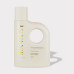 Product photograph of a sleek cream-colored L'AVANT Fresh Linen laundry detergent bottle, featuring prominent gold 'L'AVANT' lettering and a distinctive circular handle cutout, presented on a minimalist grey background
