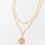Gold layered paperclip chain necklace with a textured coin pendant featuring the letter L