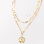 Gold layered paperclip chain necklace with a circular pendant featuring the letter N
