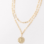 Gold layered paperclip chain necklace with a textured circular pendant featuring the letter P