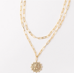 Gold layered paperclip chain necklace with a circular pendant featuring the letter S