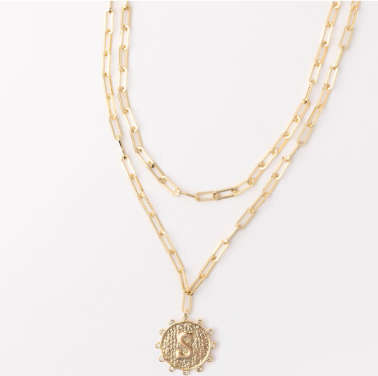 Gold layered paperclip chain necklace with a circular pendant featuring the letter S