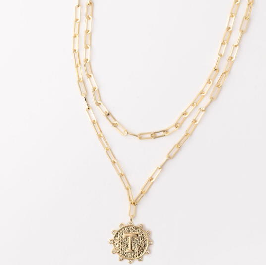 Gold layered paperclip chain necklace with a textured coin pendant featuring the letter T