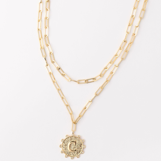 Gold layered paperclip chain necklace with a circular pendant featuring the letter C