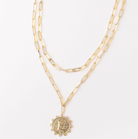 Gold layered paperclip chain necklace with a textured circular pendant featuring the letter E