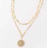 Gold layered paperclip chain necklace with a textured circular pendant featuring the letter F