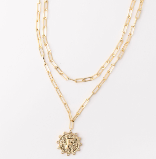 Gold layered paperclip chain necklace with a textured circular pendant featuring the letter F
