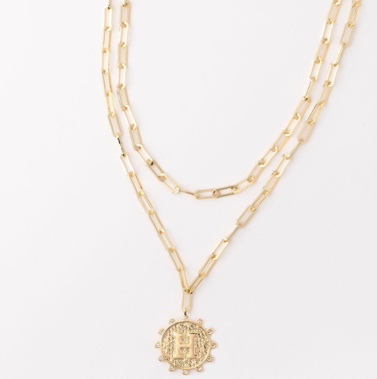 Gold layered paperclip chain necklace with a textured circular pendant featuring the letter H