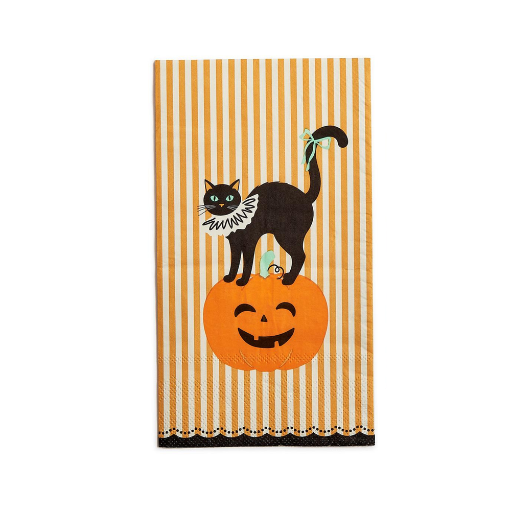 Black cat with a white ruff collar standing on a jack o lantern against a yellow and white striped background