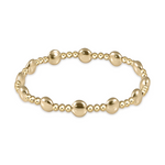 Jewelry a lustrous gold beaded stretch bracelet featuring an alternating pattern of small polished round beads and larger smooth pebble-shaped beads on a white background