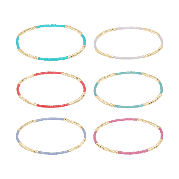 Six stretch bracelets featuring gold beads and segments of colorful glass beads