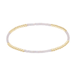 Stretch bracelet with alternating sections of gold beads and small iridescent white seed beads