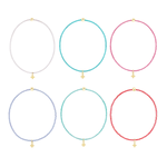 Product photography of six colorful seed bead bracelets featuring delicate gold cross charms and polished gold accent beads in vibrant shades of turquoise, lavender, and hot pink arranged in a grid on a white background