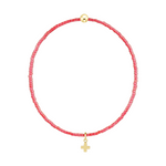 Red beaded bracelet with a gold bead and a small gold cross charm