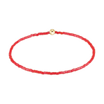 Red beaded bracelet with a single gold bead