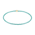 Turquoise beaded stretch bracelet with a single gold bead