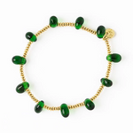 Gold beaded bracelet with twelve vibrant emerald green capsule beads and a tiny gold disc charm on a white background