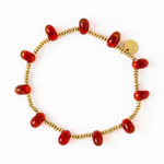 Jewelry a delicate gold beaded bracelet adorned with translucent red glass teardrop beads interspersed with small gold spacer beads and a small round gold charm