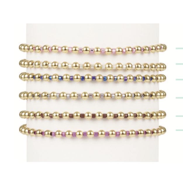 Stack of six gold bead bracelets with alternating colored accent beads