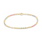 A delicate gold beaded bracelet with a single larger gold bead and colorful enamel sections in pastel pink, light blue, lavender, and white