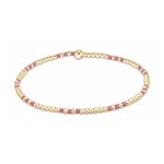 Minimalist beaded bracelet featuring alternating small gold spherical beads and fuchsia rectangular beads, secured by a larger gold spherical clasp, presented on a clean white background