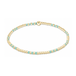 A delicate beaded bracelet featuring numerous small gold spheres interspersed with flat rectangular turquoise beads and a prominent gold spherical clasp