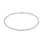 Stretch bracelet with alternating light blue seed beads and small gold metal beads