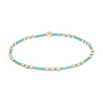 Stretch bracelet with alternating turquoise seed beads and small gold metal spheres