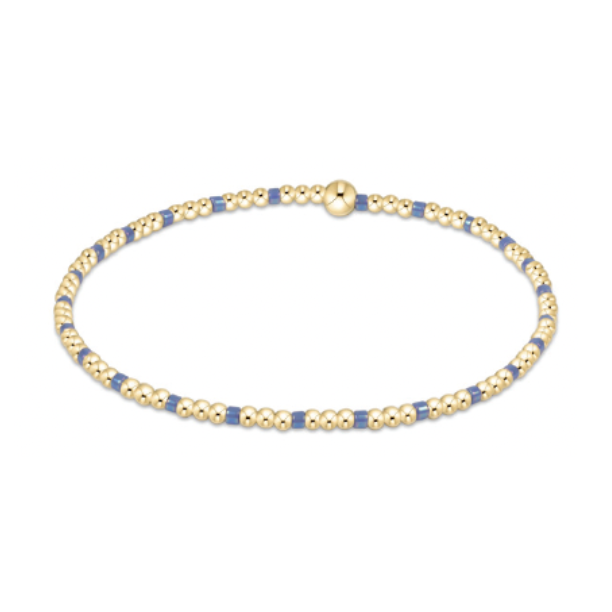 Gold and blue beaded bracelet featuring a delicate alternating pattern and a single prominent gold bead