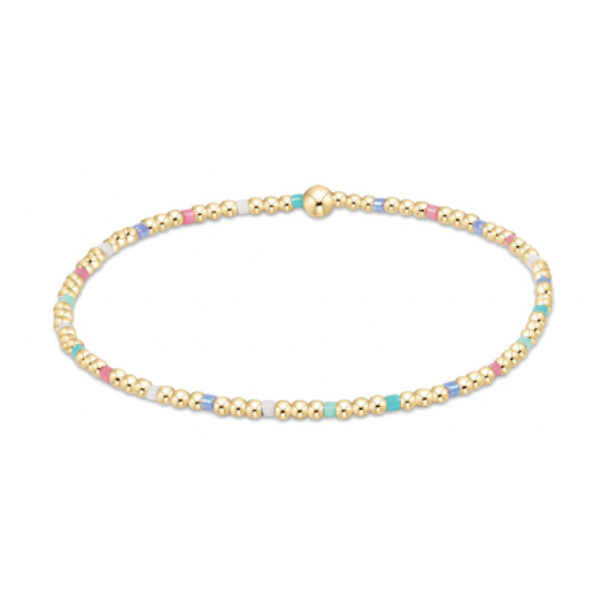 Delicate gold-toned beaded bracelet with interspersed pastel pink light blue white and turquoise enamel beads and a central larger gold bead