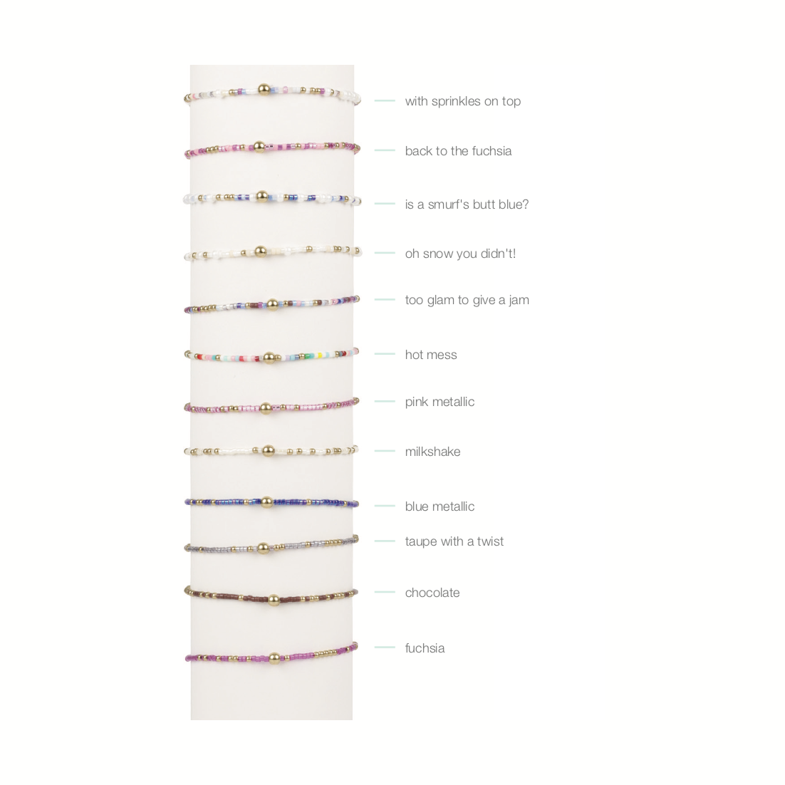 A collection of colorful seed bead bracelets displayed vertically on a white stand each featuring a central gold bead and varied designs including rainbow multi-color, vibrant fuchsia, and deep blue metallic styles