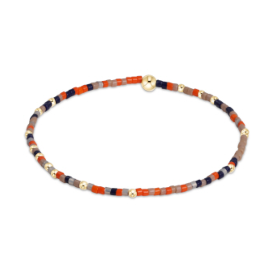 Beaded bracelet featuring tiny orange navy tan and grey glass beads interspersed with small gold spherical accents and a larger gold clasp