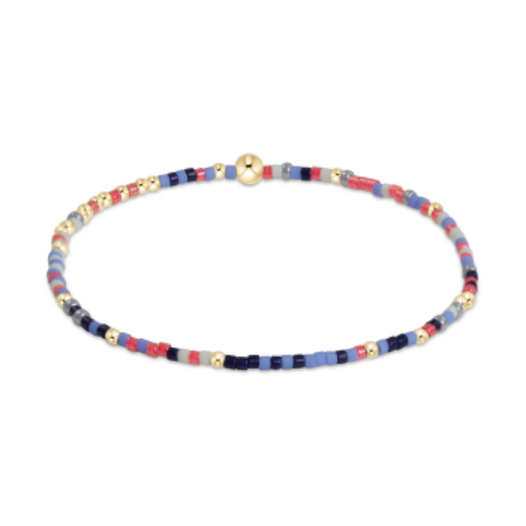 Beaded bracelet featuring a central prominent gold sphere and an alternating pattern of small gold, red, blue, and gray glass beads