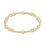 Polished yellow gold stretch bracelet featuring an alternating pattern of large and small spherical beads on a clean white background