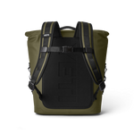 Product photograph of an olive green YETI roll-top backpack viewed from the rear, showcasing black padded shoulder straps, a chest buckle, and a large embossed YETI logo on its black back panel