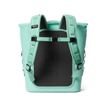YETI Panga 28 waterproof backpack in vibrant mint green featuring a prominent embossed logo on the black padded back panel and adjustable shoulder straps with a chest buckle