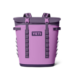 Product photography of a YETI Hopper M20 Soft Cooler Backpack in vibrant periwinkle and dark grey with a prominent YETI logo and bright pink buckles on a black studio background