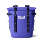 A vibrant periwinkle blue YETI cooler backpack showing its roll-top closure and white YETI logo against a black background