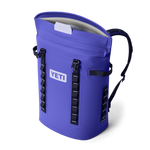 Digital product photograph of a vibrant purple Yeti Hopper M20 soft cooler backpack with a partially open magnetic MagShield Access top, prominent YETI logo, and black webbing straps with white stitch details