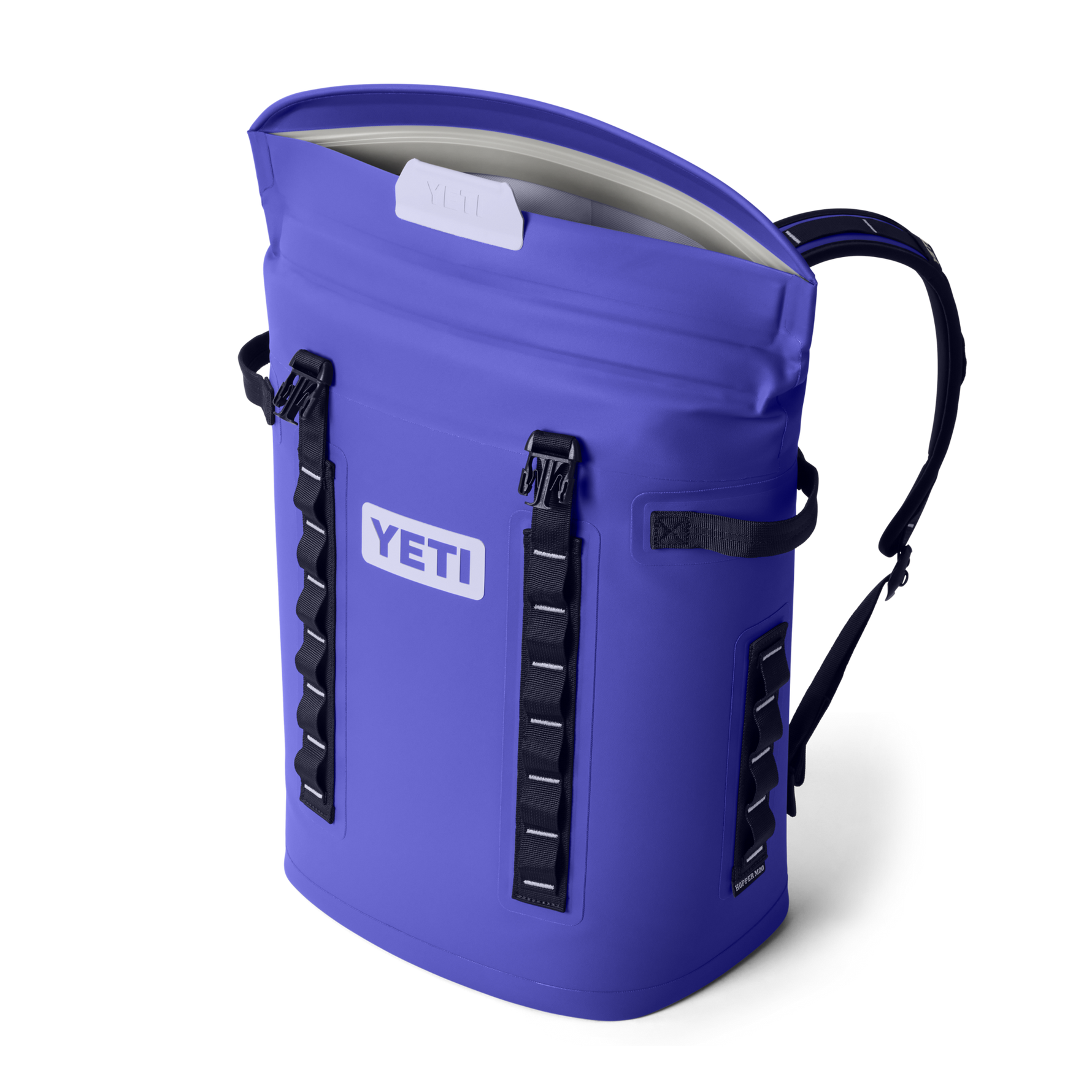 Digital product photograph of a vibrant purple Yeti Hopper M20 soft cooler backpack with a partially open magnetic MagShield Access top, prominent YETI logo, and black webbing straps with white stitch details
