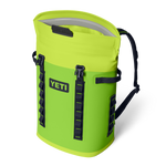 Product photography by YETI of a vibrant lime green waterproof roll-top backpack cooler with a black YETI logo on an isolated black background