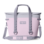 Product photography of a pink Yeti Hopper M30 soft cooler bag featuring a light gray magnetic roll-top closure, robust gray carry straps, and prominent front logo against a black background