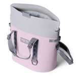 A pink and light gray YETI Hopper M30 soft cooler bag shown partially open with its magnetic closure system, featuring the YETI logo and a detachable shoulder strap