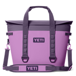 YETI Hopper M30 soft cooler bag in vibrant lavender with charcoal grey top, prominent YETI logos, and a detachable shoulder strap with purple clips