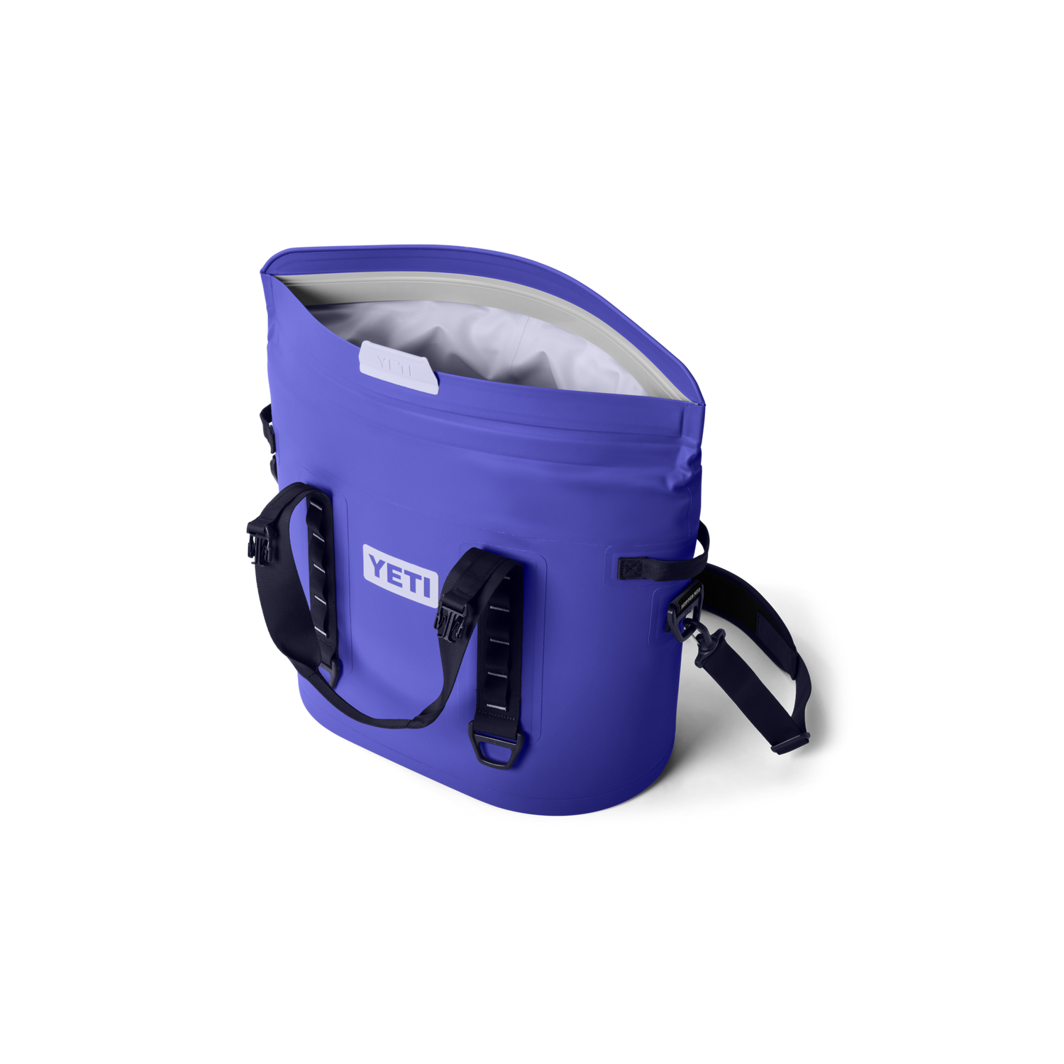 Periwinkle blue YETI Hopper M20 soft cooler bag open to show its light grey interior with the white YETI logo on the side and a black shoulder strap featuring HOPPER M20 text against a black background